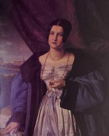 A painting of Grand Duchess Elizaveta Mikhailovna from the early 1840s. She has dark hair piled on her head, and a pensive look on her face. She's wearing a long, looped chain necklace, a pale silk dress with a purple bow at the waist, and a fur-trimmed blue robe.