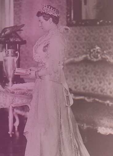 Archduchess Margarethe Klementine wearing Empress Eugénie's Pearl and Diamond Tiara. She's in profile, holding a small book and wearing a white, lacy day dress.
