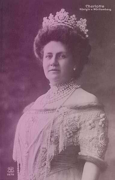 The Württemberg diamond diadem, as seen on Queen Charlotte in the early 20th century. Charlotte is wearing an off-the-shoulder dress trimmed with fur, with a multitude of pearl and diamond necklaces.